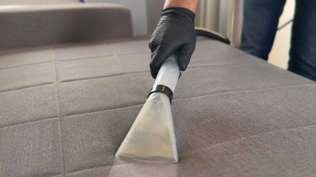 Técnico da Panda Clean extraindo a sujeira de um sofá com bocal profissional